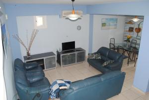 a living room with two blue couches and a table at Villa Lachi in Polis Chrysochous