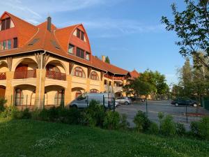 budynek z pomarańczowym dachem na parkingu w obiekcie Beach Resort Fonyód w mieście Fonyód