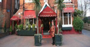 una mujer parada frente a una tienda en Tamasha Hotel, en Bromley