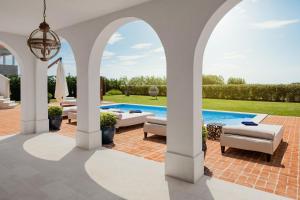 an arched patio with a swimming pool and tables and chairs at Villa Ivana in Vabriga