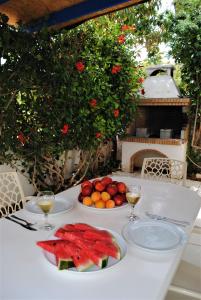 a table with two plates of fruit and glasses of wine at Villa Lachi in Polis Chrysochous