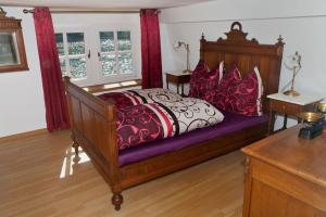 a bedroom with a wooden bed with red and black pillows at Altes Fährhaus an der Mosel anno1633 in Traben-Trarbach