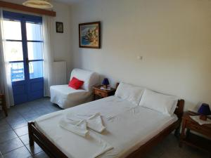 a bedroom with a bed and a chair and a window at Blue House in Acherounes