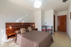 Schlafzimmer mit einem großen Bett mit einem Kopfteil aus Holz in der Unterkunft Hotel Ritz in Alta Gracia