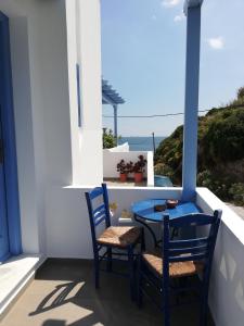 a blue table and chairs on a balcony with the ocean at Blue House in Acherounes