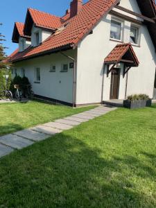 a white house with a red roof at Dom Wypoczynkowy Monika in Białogóra