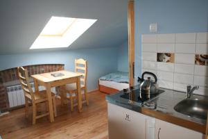 a kitchen with a sink and a table with a kettle at Apartament Rodzinny in Nowy Targ