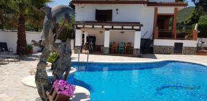 リャゴステラにあるvilla arandaの像のあるプールが家の隣にある