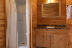 ein Bad mit einer Dusche und einem Waschbecken in der Unterkunft Fairways Cottages in Cavendish