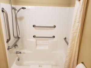 a bathroom with a shower and a tub and a toilet at Cobblestone Inn & Suites - Holyoke in Holyoke +27 photos