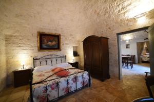 1 dormitorio con 1 cama en una pared de piedra en Trullo Barratta en Martina Franca