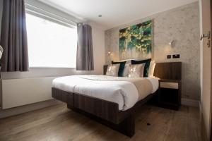 Postel nebo postele na pokoji v ubytování Signature Suites