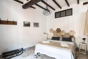 una camera con un letto in una stanza con pareti bianche di ManillaHouse a Montepulciano