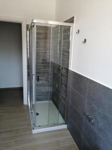 W łazience znajduje się przeszklona kabina prysznicowa z przeszklonymi drzwiami. w obiekcie Appartamento fronte mare w mieście Porto Recanati