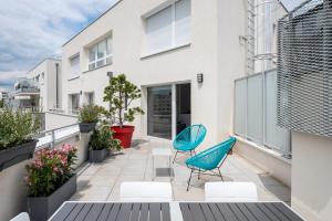 Apartamento con balcón con 2 sillas y plantas en Appartement de standing avec grande terrasse en Villeurbanne