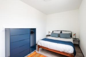 1 dormitorio con 1 cama y vestidor azul en Appartement de standing avec grande terrasse en Villeurbanne