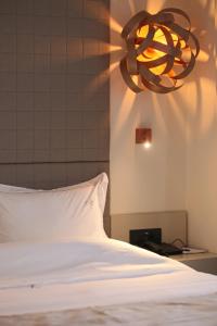 1 cama con almohada blanca y lámpara de araña en Athinais Luxury Apartments, en Chaniotis