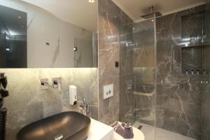 a bathroom with a shower with a sink and a toilet at Athinais Luxury Apartments in Hanioti