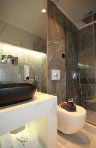 a bathroom with a sink and a toilet at Athinais Luxury Apartments in Hanioti