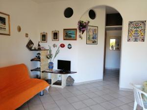 a living room with an orange couch and a table at Casa Esperanto in Favignana