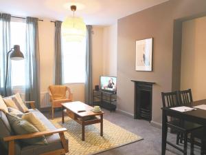 Homely Serviced Apartments - Figtree في شيفيلد: غرفة معيشة مع أريكة وطاولة