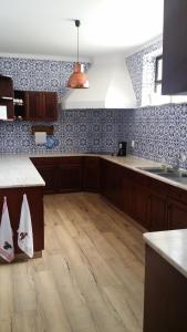 a kitchen with wooden floors and blue and white wallpaper at BB Silvercoast Casa das Flores in Santa Catarina