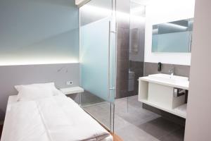 a bathroom with a bed and a shower and a sink at Fairotel in Filderstadt