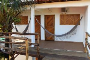 a room with a hammock on the front of a house at Pousada Rio Sagi in Baía Formosa