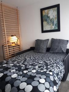 a bedroom with a black and white comforter on a bed at Talence, studio cosy 27 M2, Bordeaux 10 mn en tram in Talence
