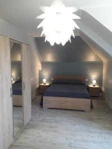 La Maison au Cœur de l Auvergne في Lanobre: غرفة نوم بسرير وثريا