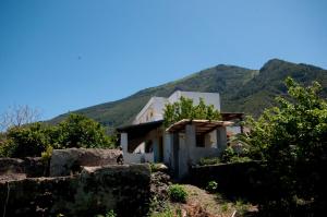 a house on a hill with mountains in the background at Casa Vacanze Dell'Avvocato in Malfa