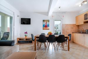 a kitchen and dining room with a table and chairs at Apartments Mijo in Dugi Rat