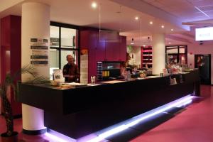 a man standing behind a counter in a restaurant at Jugendherberge-Berlin-International in Berlin