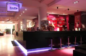 a bar with stools in a room with red lighting at Jugendherberge-Berlin-International in Berlin