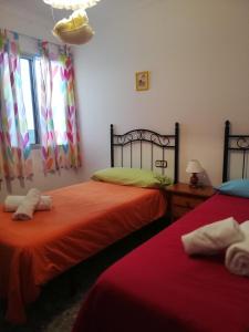 a bedroom with two beds and a window at Piso Tarayuela in Barbate