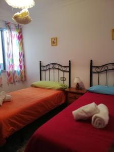 1 dormitorio con 2 camas y toallas. en Piso Tarayuela, en Barbate