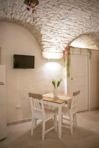 a dining room with a table and two chairs at La pietra Maga in Martina Franca