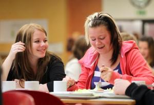 two women sitting at a table eating food at Jugendherberge-Berlin-International in Berlin
