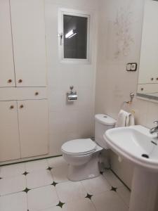 a white bathroom with a toilet and a sink at Piso Tarayuela in Barbate +41 photos
