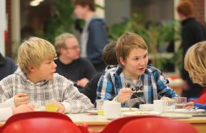 two young boys sitting at a table eating food at Jugendherberge-Berlin-International in Berlin