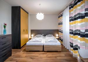 a bedroom with two beds and a chandelier at Apartamenty Klifowa z widokiem na morze in Trzęsacz
