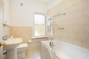 łazienka z umywalką, wanną i toaletą w obiekcie Hotel Continental w mieście Whitstable