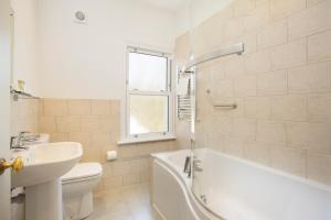 a bathroom with a sink and a tub and a toilet at Hotel Continental in Whitstable