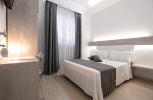 een witte slaapkamer met een bed en een raam bij Imera B&B in Favignana