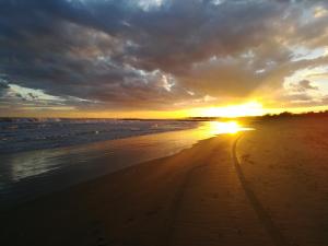 a sunset on a beach with the sun setting at Bungalow Gambaro 2 in Cavallino-Treporti