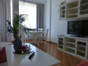 Una sala de estar con una mesa y un televisor. en Appartamento centro terme merano, en Merano