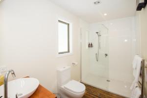 a bathroom with a shower and a toilet and a sink at Kinross Boutique Vineyard Hotel in Gibbston