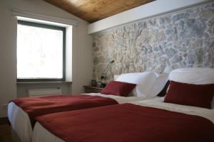 a bedroom with two beds and a stone wall at Quinta Vale da Roca in Sintra