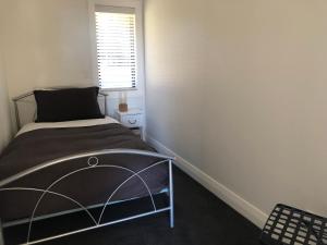 a small bedroom with a bed and a window at Twizel - Arohanui Cottage in Twizel