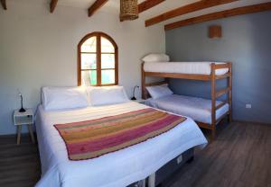 Hotel Jardin Atacama في سان بيدرو دي أتاكاما: غرفة نوم بسريرين بطابقين ونافذة
